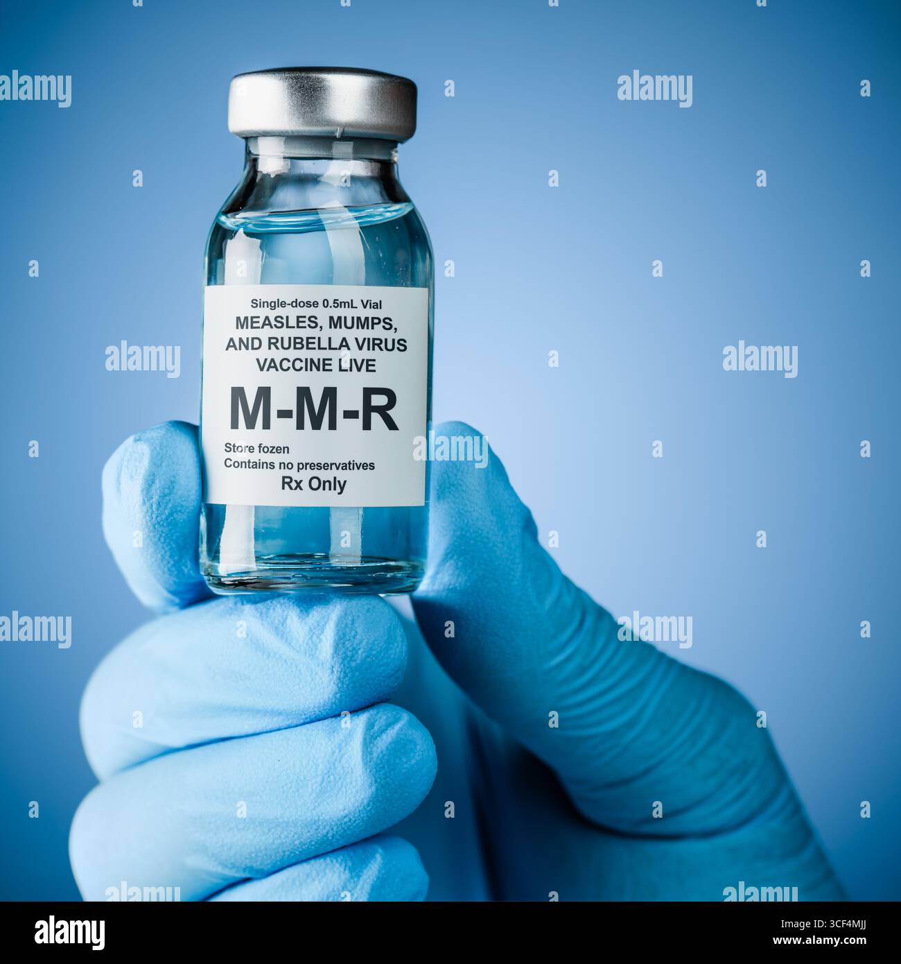 Infermiere mano in guanti medici blu che contengono una bottiglia di vaccino con testo MMR. Concetto di assistenza sanitaria di prevenzione o trattamento di morbillo, parotite e rube Foto Stock