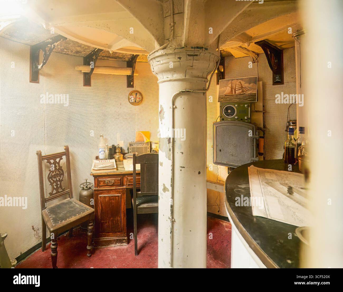 La sala faro d'epoca presenta mobili in legno e decorazioni nautiche, creando un'atmosfera calda e invitante. Hammerfyr, faro di Hammeren, Ronne, Foto Stock