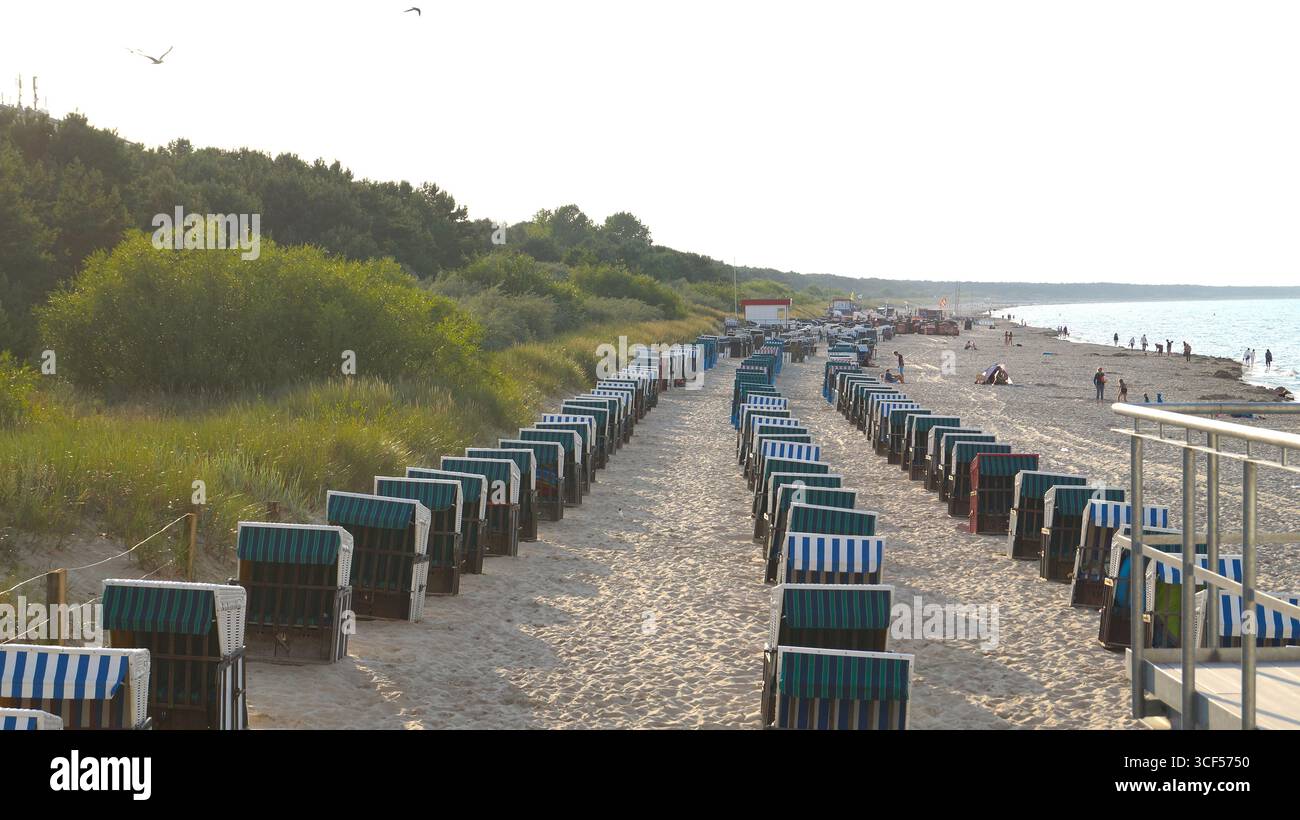 Tre file di sedie a sdraio tradizionali (Strandkorb) sulla spiaggia sabbiosa di Zinnowitz, sull'isola di Usedom, il classico scenario delle vacanze sul mare del Mar Baltico Foto Stock
