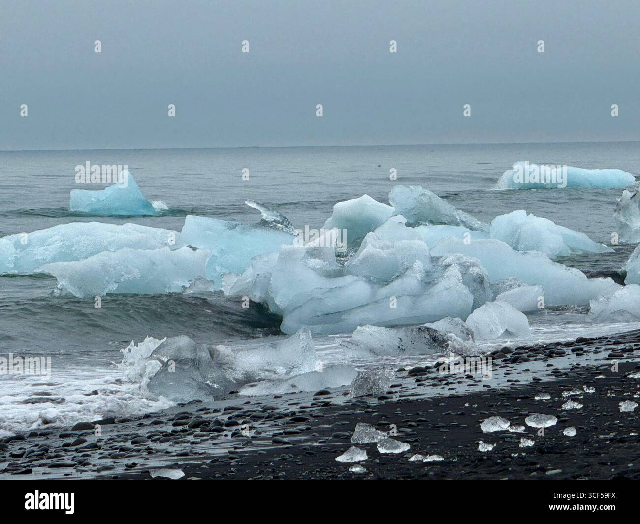 La famosa spiaggia di sabbia nera Diamond Beach in Islanda è conosciuta per gli iceberg che galleggiano nell'oceano dalla laguna del ghiacciaio Jokusarlon Foto Stock