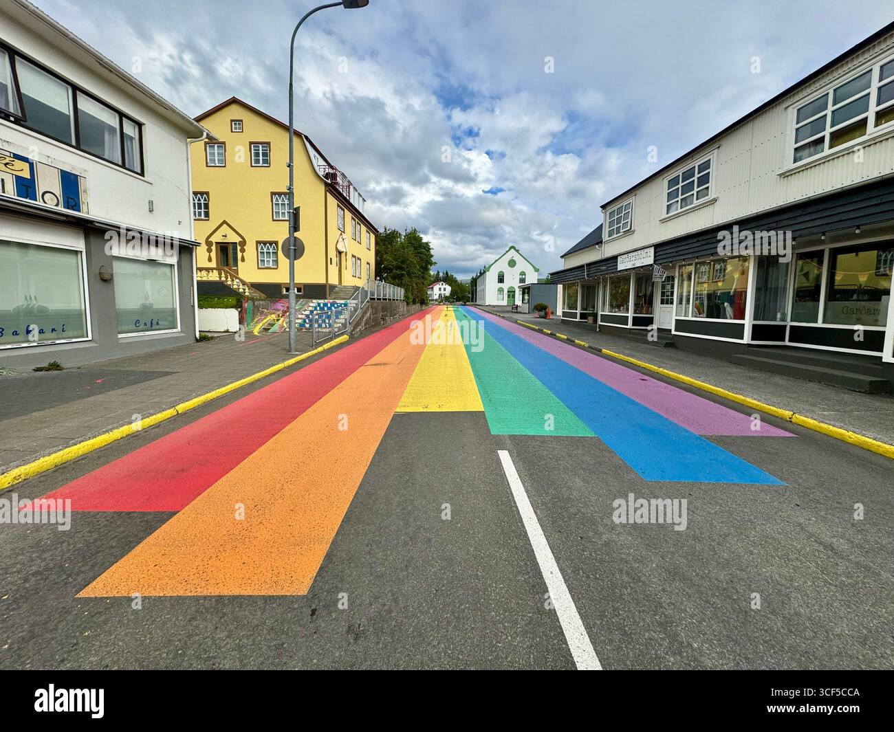 Il villaggio di Husavik ha la sua 'Rainbow Street', un arcobaleno dipinto in modo vibrante in una sezione di Gardarsbraut Road. - Immagine stock catturata con smartphone
