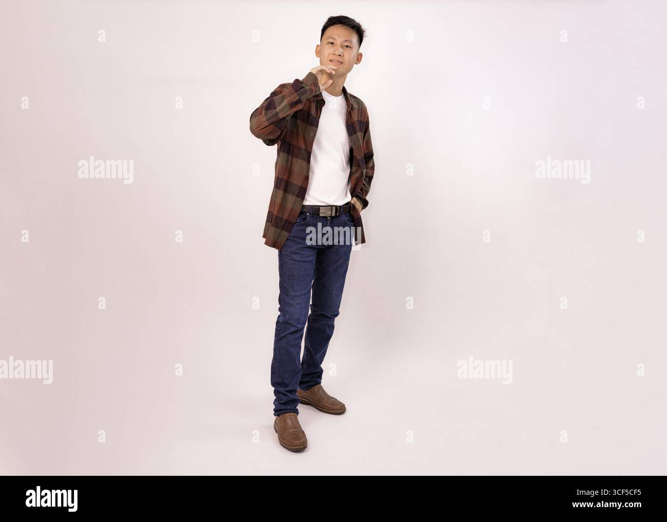 un giovane casual con una camicia a quadri e jeans rivolti verso l'esterno Foto Stock