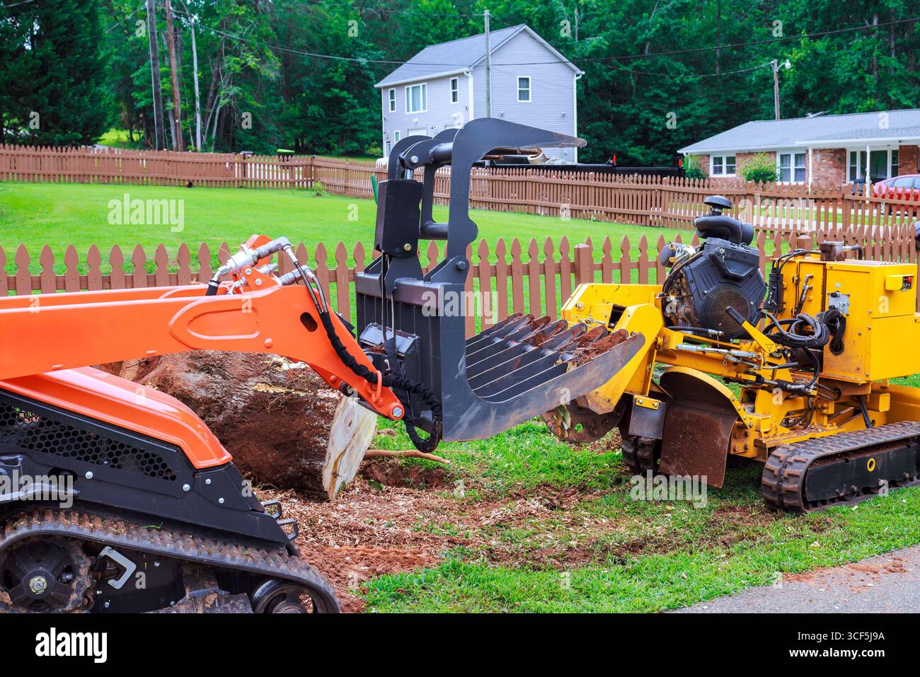 Le attrezzature per l'edilizia sono utilizzate per lavori di architettura paesaggistica, bonifica dei terreni e rimozione di ceppi di alberi nelle zone residenziali. Foto Stock