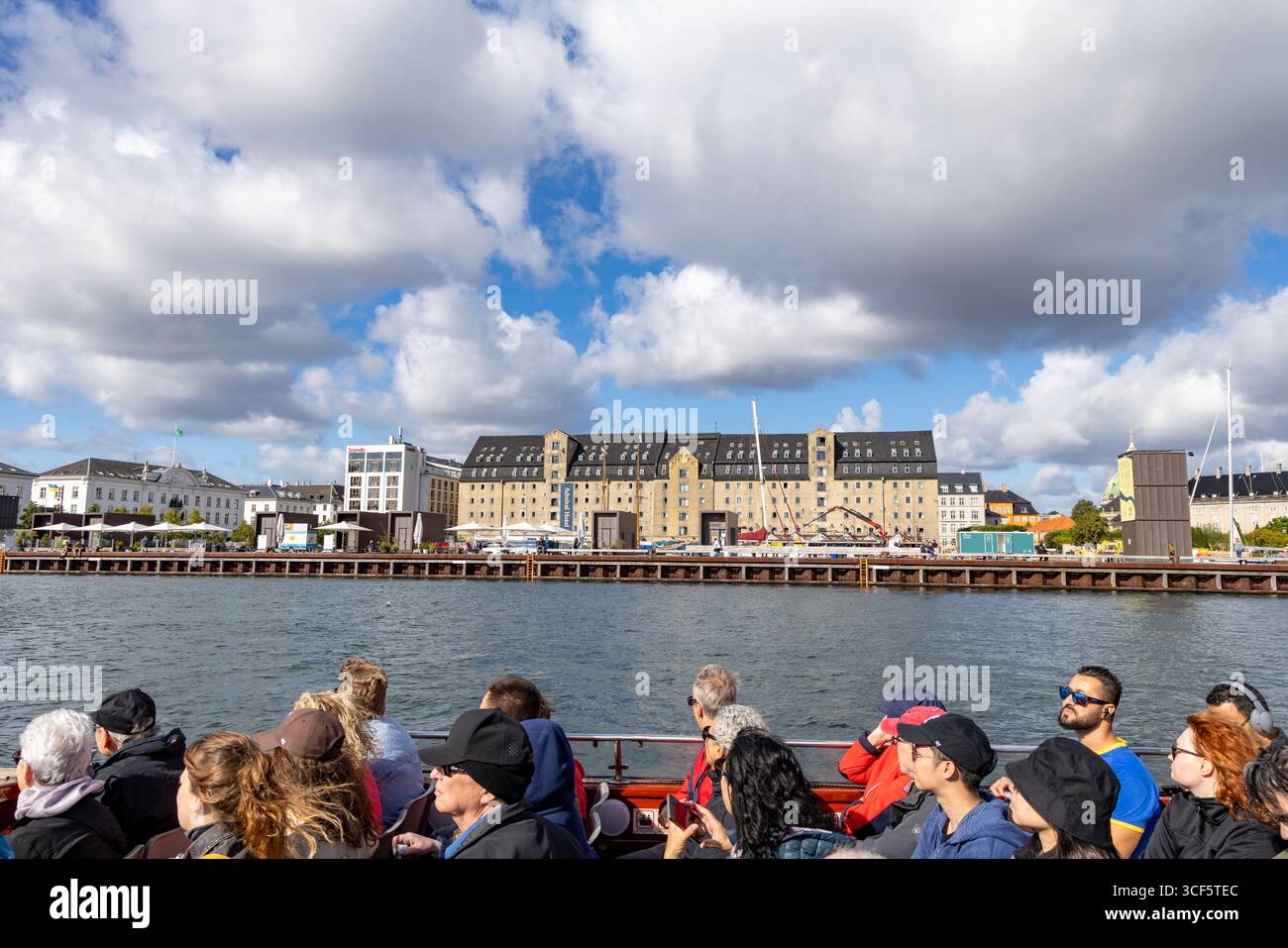 I turisti in un tour panoramico in barca sui canali passano davanti all'Admiral Hotel a 4 stelle a Copenhagen, l'hotel si trova all'interno di un ex magazzino ristrutturato Foto Stock