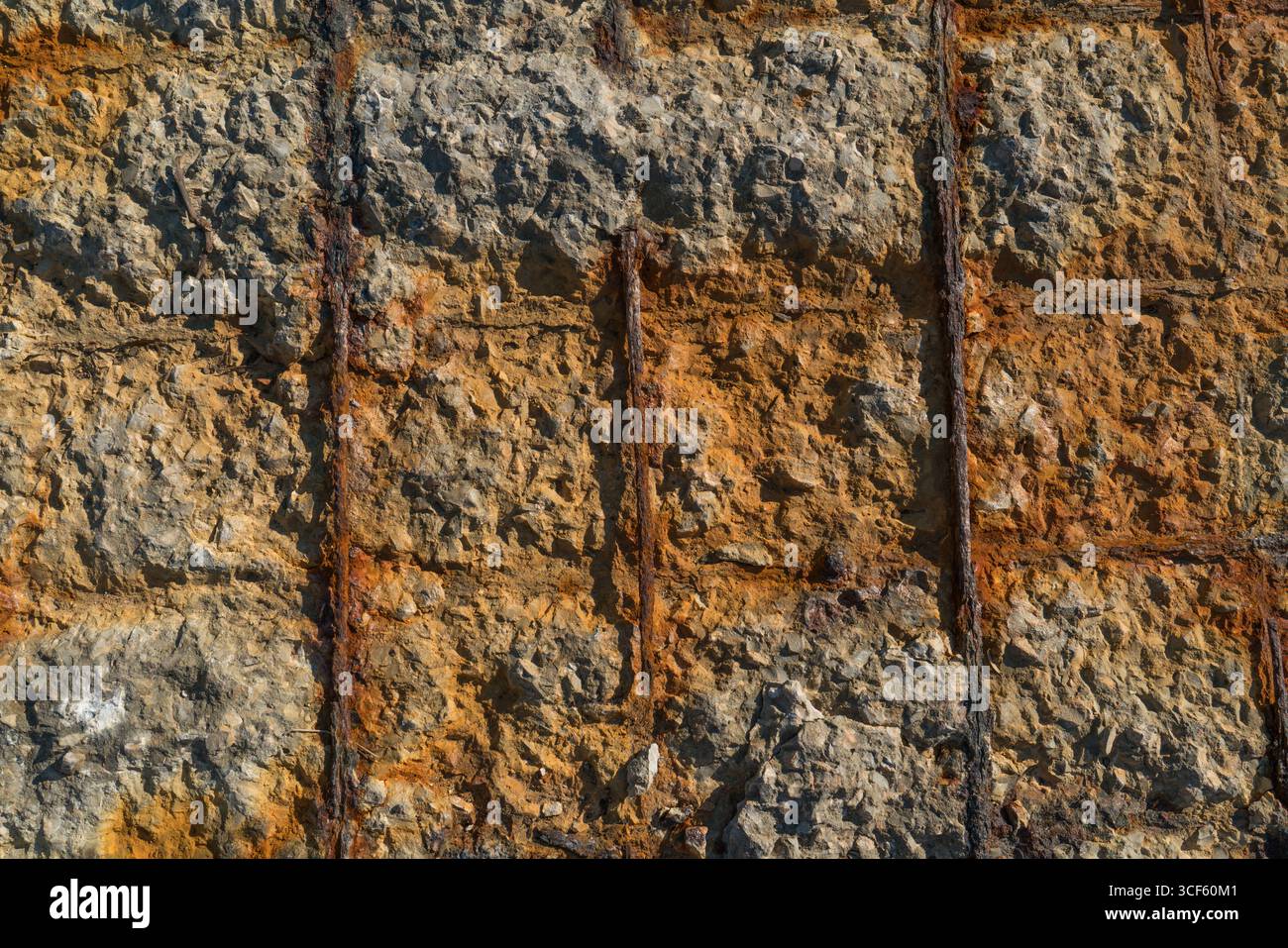 Barre arrugginite attraverso il muro di pietra Foto Stock