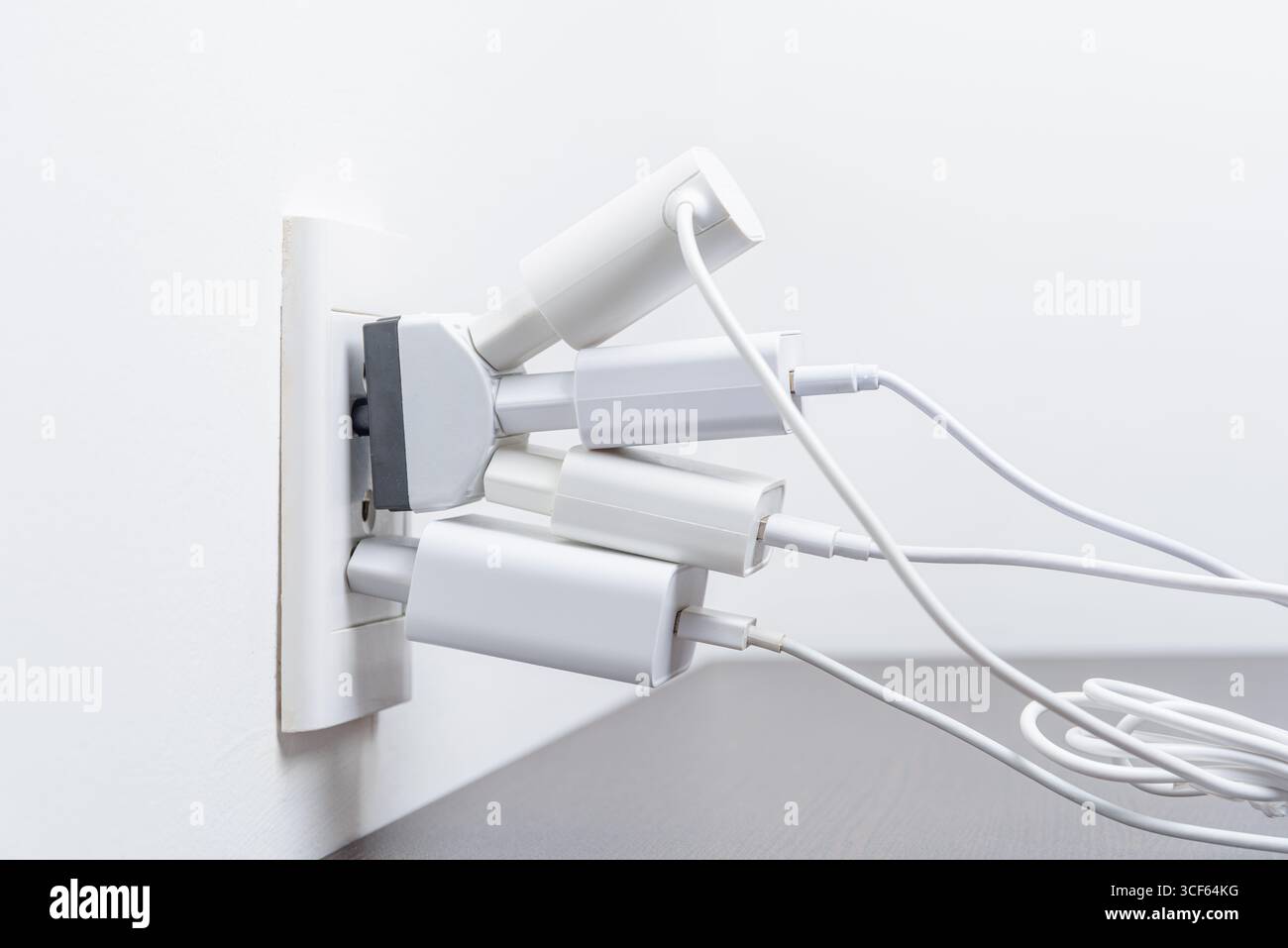 Poche spine elettriche nella presa. Sovraccarico elettrico Foto Stock