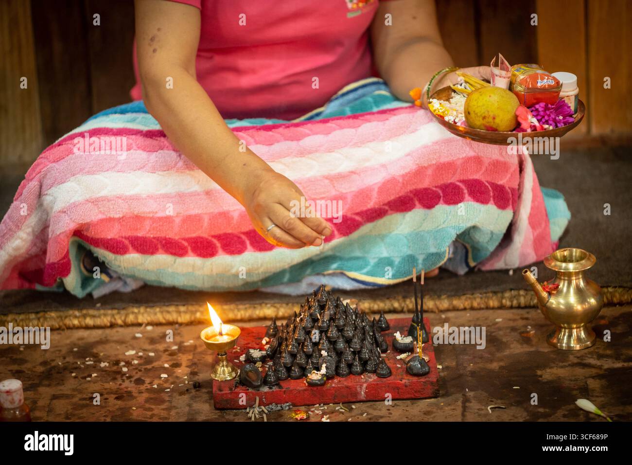 Lalitpur, Nepal. 21 agosto 2025. Un devoto adora piccoli stupa con offerte in celebrazione del Gunla Festival a Lalitpur, Nepal, 21 agosto 2025. Il Gunla Festival, che dura un mese, è uno dei principali festival della comunità buddista Newar, durante i quali recitano le scritture, osservano velocemente e visitano luoghi di culto. Crediti: Hari Maharjan/Xinhua/Alamy Live News Foto Stock