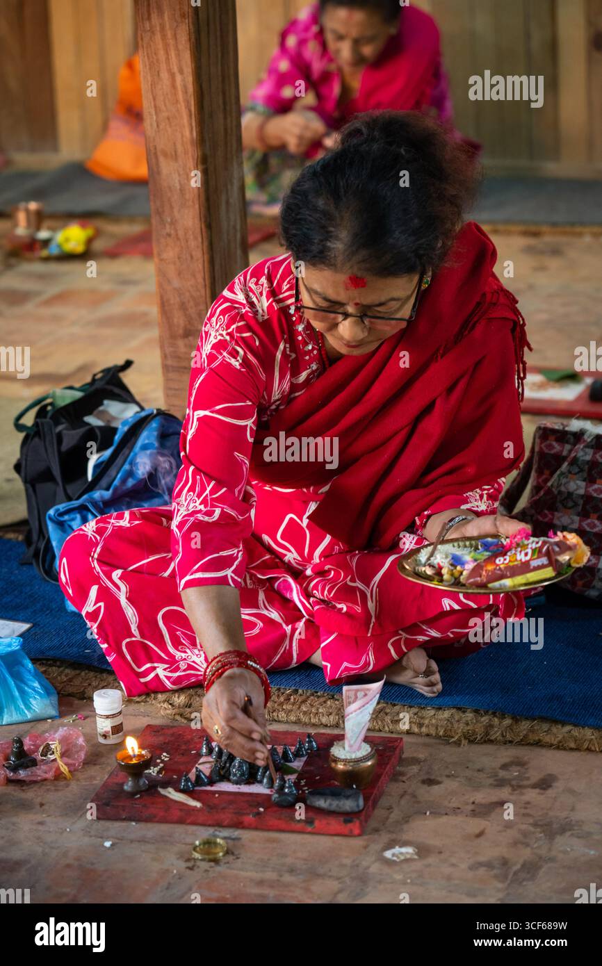 Lalitpur, Nepal. 21 agosto 2025. Un devoto adora piccoli stupa con offerte in celebrazione del Gunla Festival a Lalitpur, Nepal, 21 agosto 2025. Il Gunla Festival, che dura un mese, è uno dei principali festival della comunità buddista Newar, durante i quali recitano le scritture, osservano velocemente e visitano luoghi di culto. Crediti: Hari Maharjan/Xinhua/Alamy Live News Foto Stock