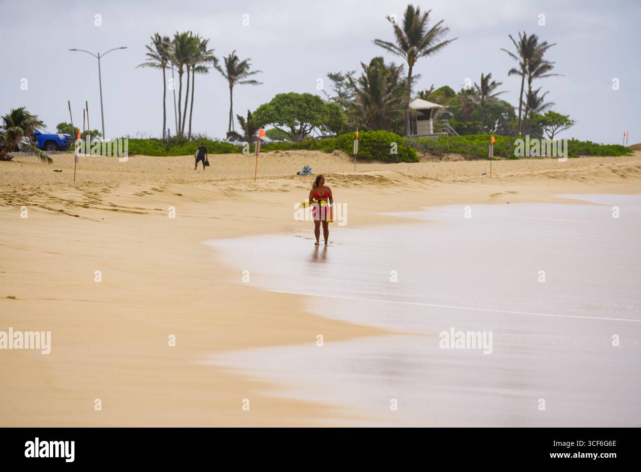 I bagnini si precipitano nel surf per salvare l'uomo in difficoltà al Sandy Beach Park di Honolulu, un momento urgente di coraggio e precisione sul bordo dell'oceano. Foto Stock