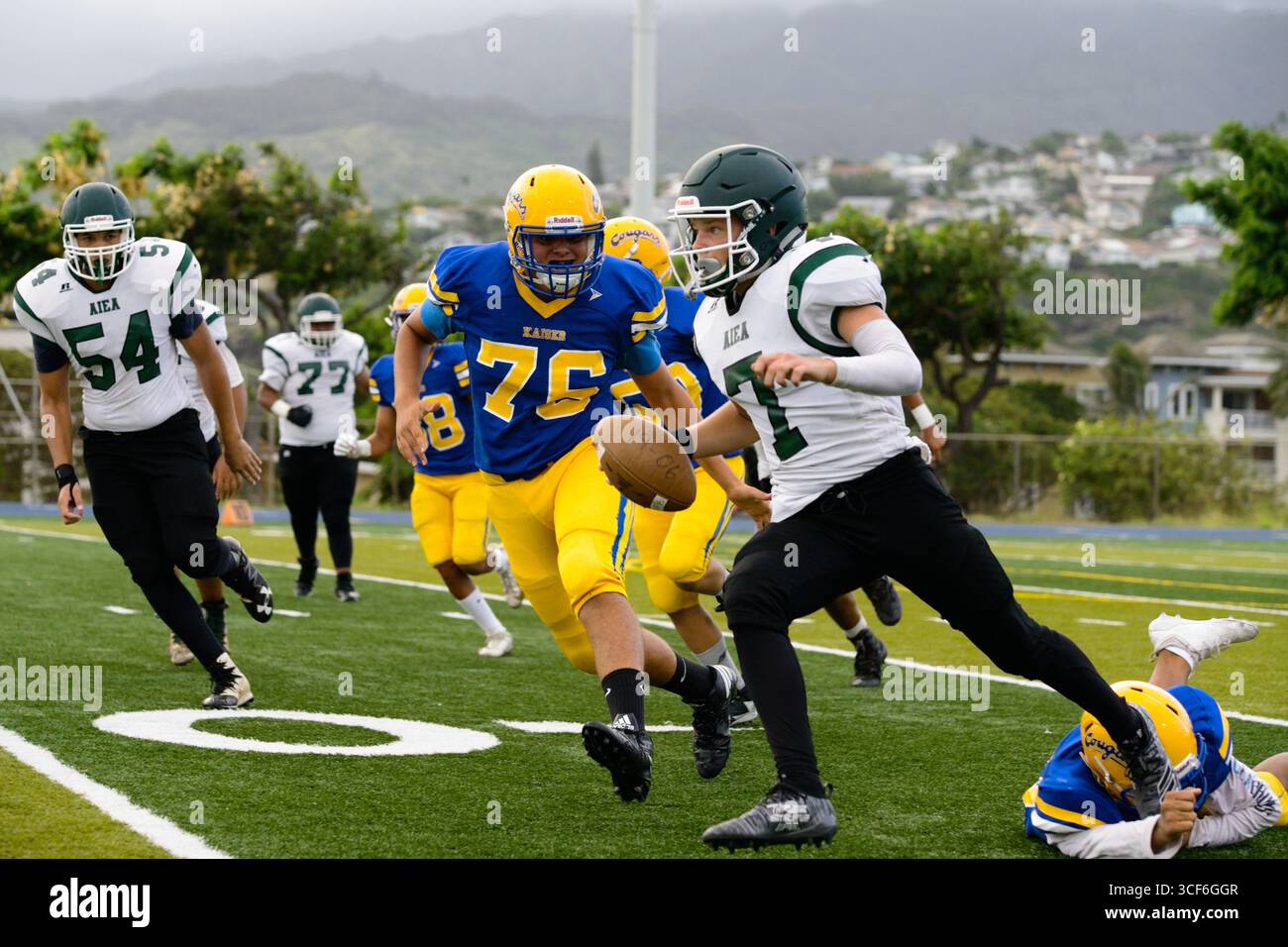 Il quarterback dell'Aiea High School Football superò i difensori della linea delle 30 yard e si diresse verso la end zone nella partita di rivalità contro il Kaiser Foto Stock
