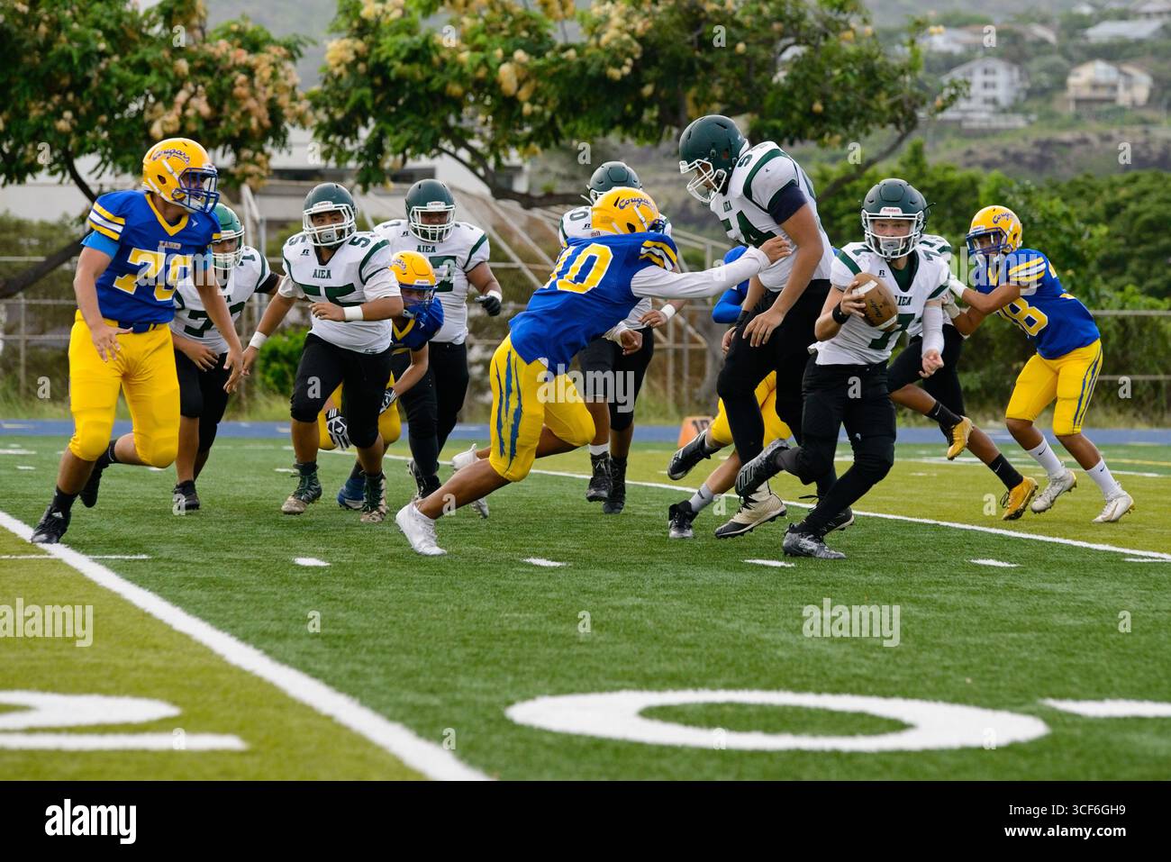 Il quarterback dell'Aiea High School Football superò i difensori della linea delle 30 yard e si diresse verso la end zone nella partita di rivalità contro il Kaiser Foto Stock