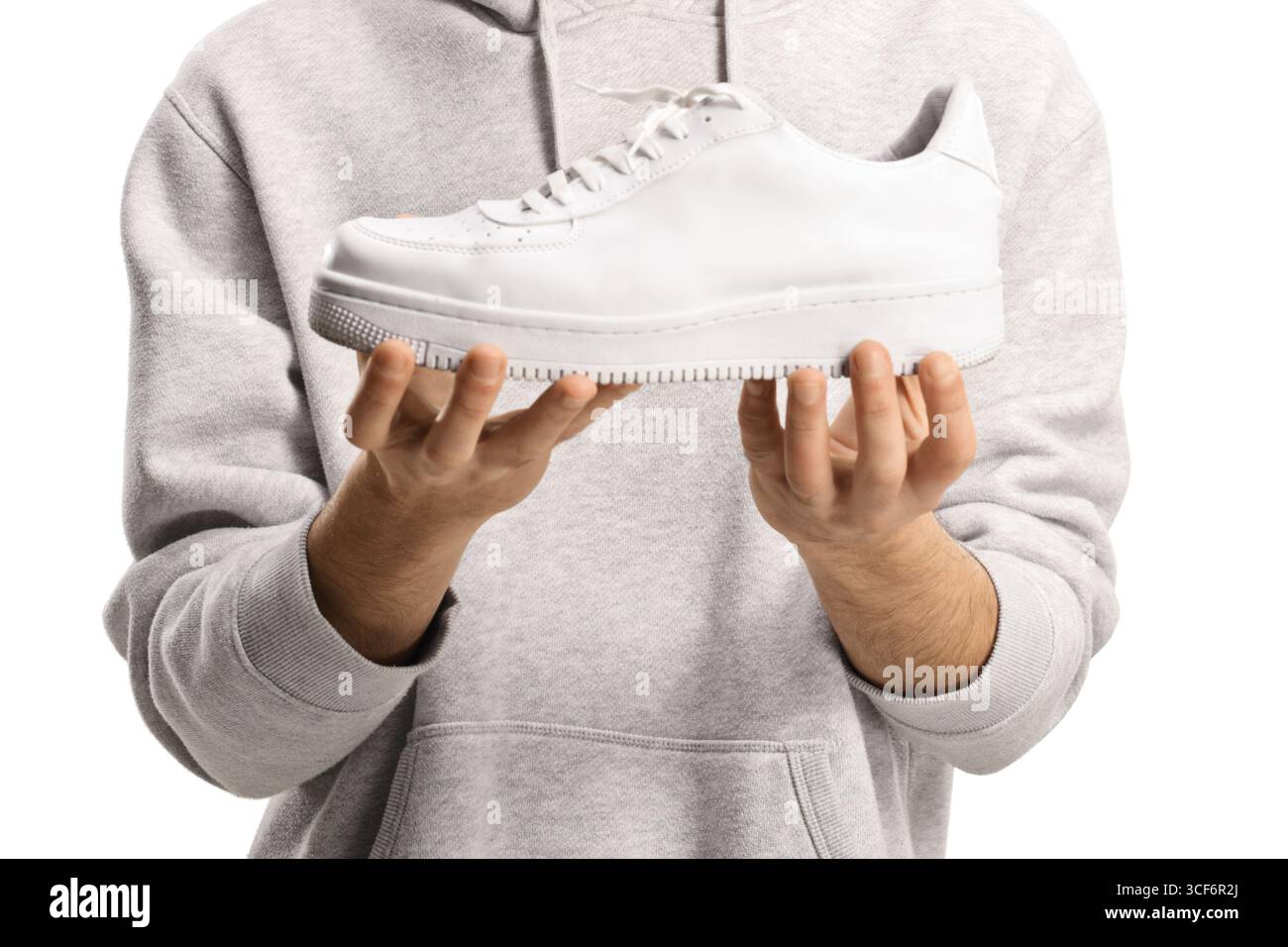 Mani maschili che reggono una sneaker bianca alla moda isolata su sfondo bianco Foto Stock