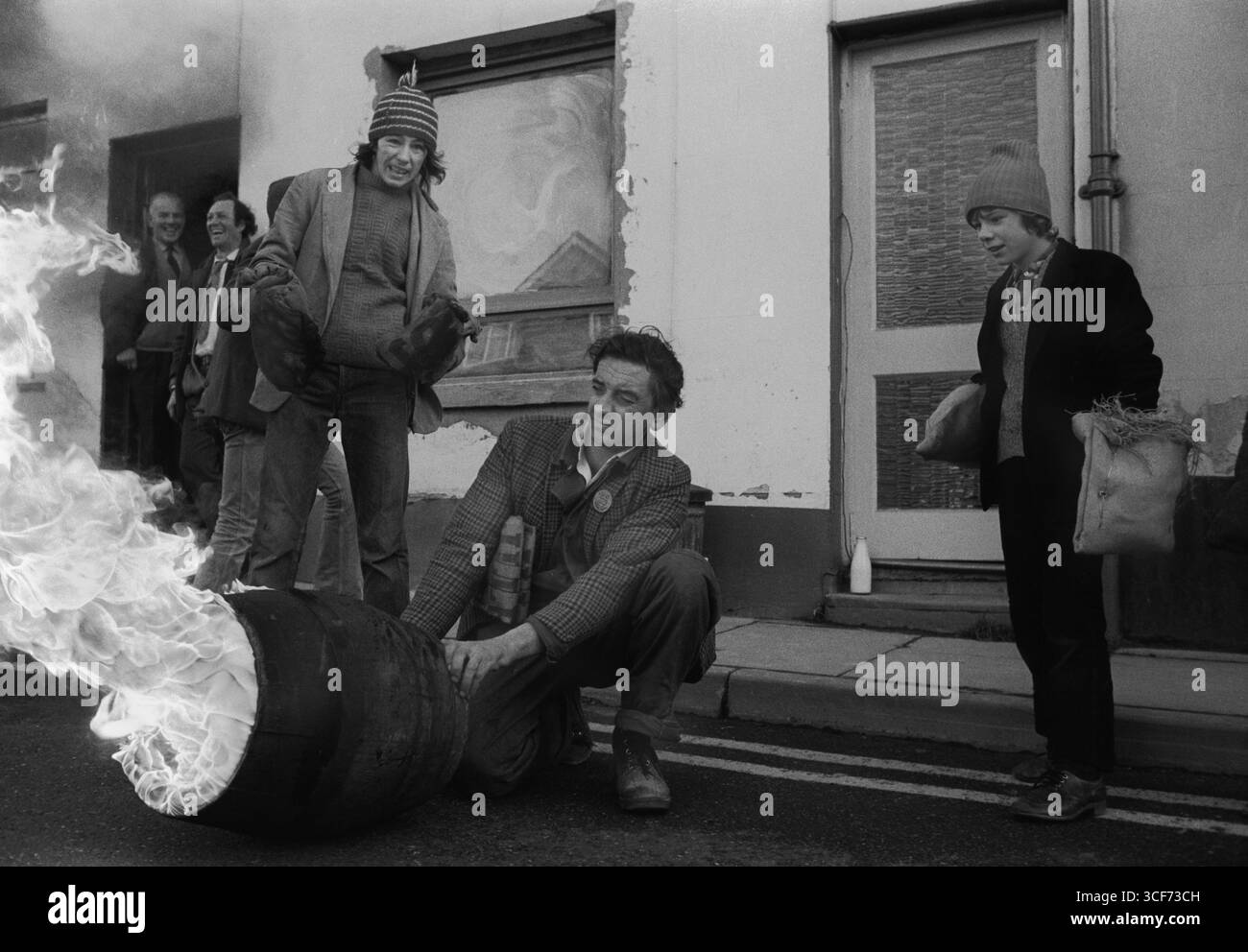 Tar Barrel Rolling, Ottery St Mary, Devon. Le botti di catrame fiammeggianti attraversano la strada del villaggio durante la notte. Si tratta di una piccola botte preparata per essere trasportata da un giovane adulto. I barili adulti sono più grandi e più tardi la sera. Inghilterra 5 novembre 1973 1970s Regno Unito HOMER SYKES. Foto Stock