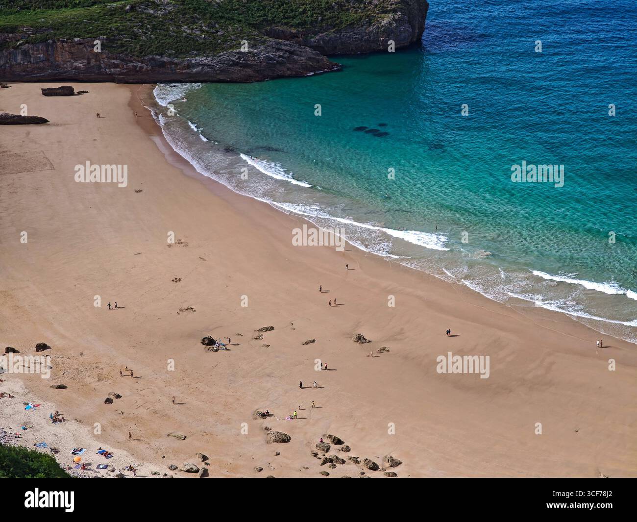 Le sabbie dorate incontrano le vibranti scogliere color smeraldo a Playa de la Ballota, una spiaggia tranquilla perfetta per rilassarsi ed esplorare le Asturie. Foto Stock