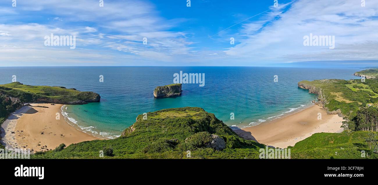 La vista mozzafiato presenta le spiagge di Andrín e Ballota con Castro Ballota che separa le loro sabbie dorate sotto un cielo azzurro. Foto Stock