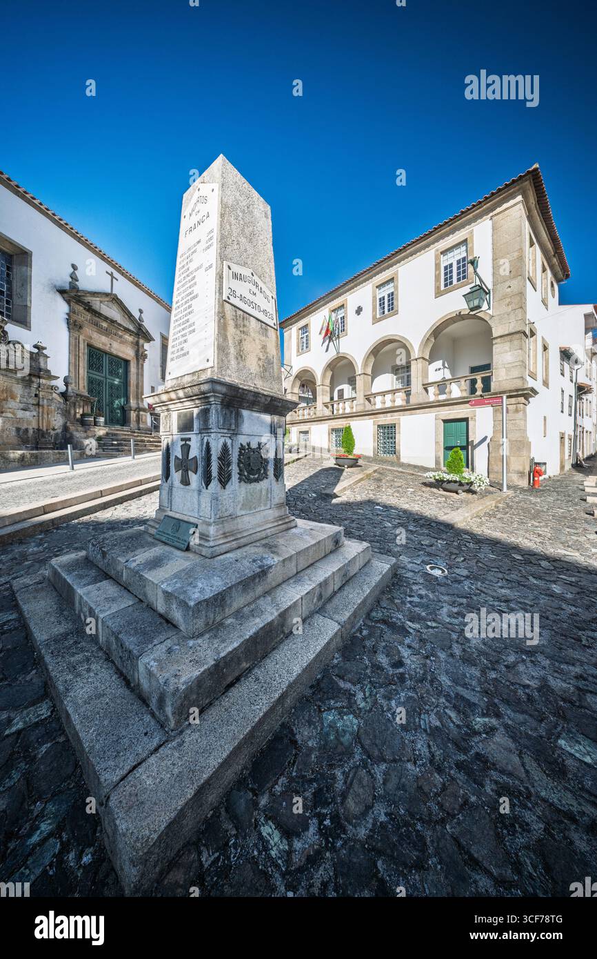 Pietra e memoria a Braganza — l'obelisco onora i caduti della grande Guerra, in piedi solenni tra São Vicente e il Edifício do Principal. Foto Stock