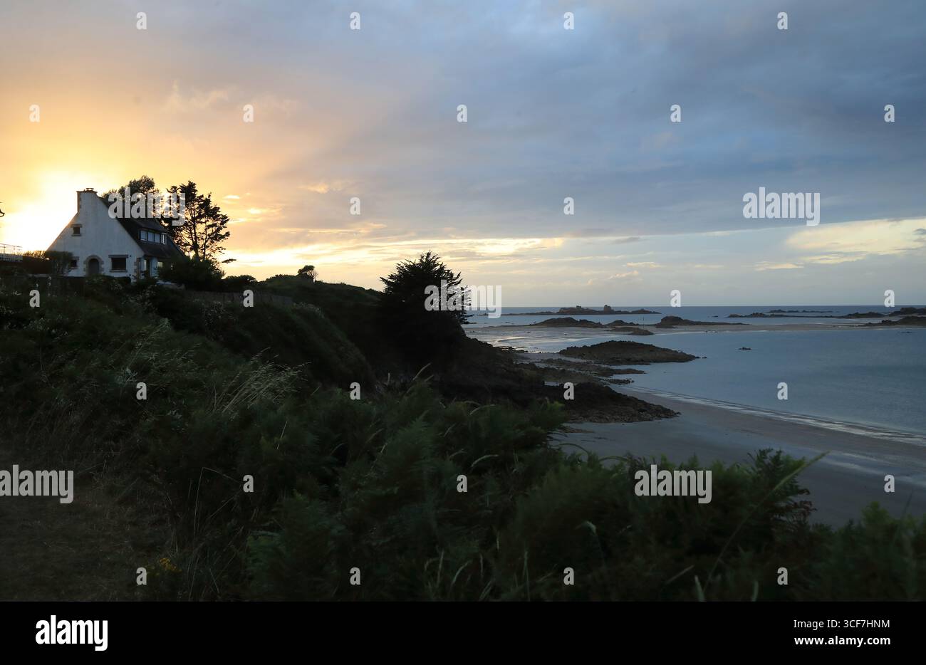 Casa isolata in Bretagna francese al tramonto con una bella sfumatura di colore nel cielo Foto Stock