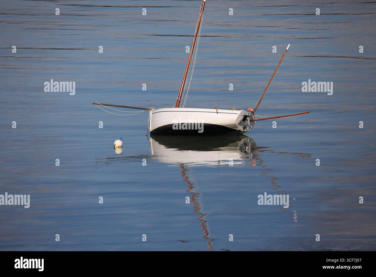 Barca a vela isolata e il suo riflesso in acqua Foto Stock