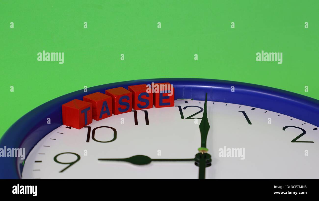 Ho messo un blocco di legno sopra l'orologio con la parola TASSE scritta sopra i cubi con lettere adesive italiane Foto Stock