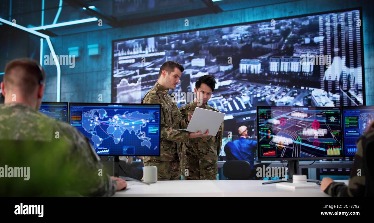 I soldati utilizzano la tecnologia per monitorare i dati nel centro di controllo militare. Lavorano più persone con background diversi Foto Stock
