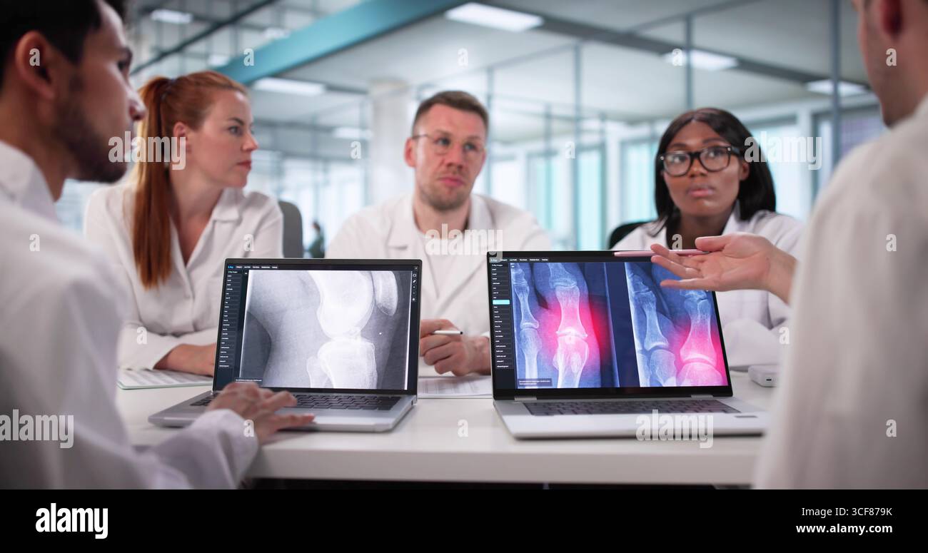 Diversi radiologi che guidano la conferenza con notebook tra i gruppi di medici. Foto Stock