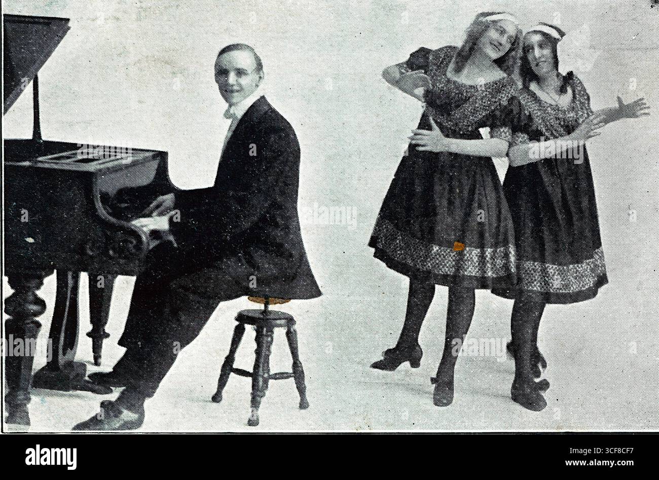 I 3 Osram, pubblicizzati nel 1910 come “The Leading Lights of the Dancing World” e “The Neatest and Brightest Act in Vaudeville”, sono catturati in un dinamico ritratto in studio che fonde stile musicale e coreografico. Un pianista seduto fissa la composizione, mentre due interpreti femminili con abiti identici colpiscono una posa teatrale. I loro grembiuli e copricapo con motivi geometrici evocano costumi folcloristici o di novità, emblematici della varietà edoardiana. Lo sfondo semplice aumenta la loro presenza espressiva. Alcuni danni alla superficie dell'originale. Foto Stock