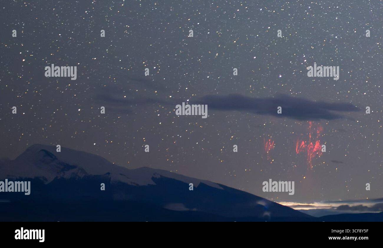 Tianjin. 21 agosto 2025. Questa foto scattata il 21 agosto 2025 mostra un raro fenomeno dei fulmini rossi noto come "sprite rossi" catturato vicino al Monte Kangrinboqe, un sito sacro per i seguaci dell'induismo e del buddismo situato a un'altitudine di 6.656 metri nella regione autonoma di Xizang, nella Cina sud-occidentale. PER ACCOMPAGNARE IL "raro fulmine rosso" fotografato nello Xizang di SW China Credit: Zhou Bo/Xinhua/Alamy Live News Foto Stock