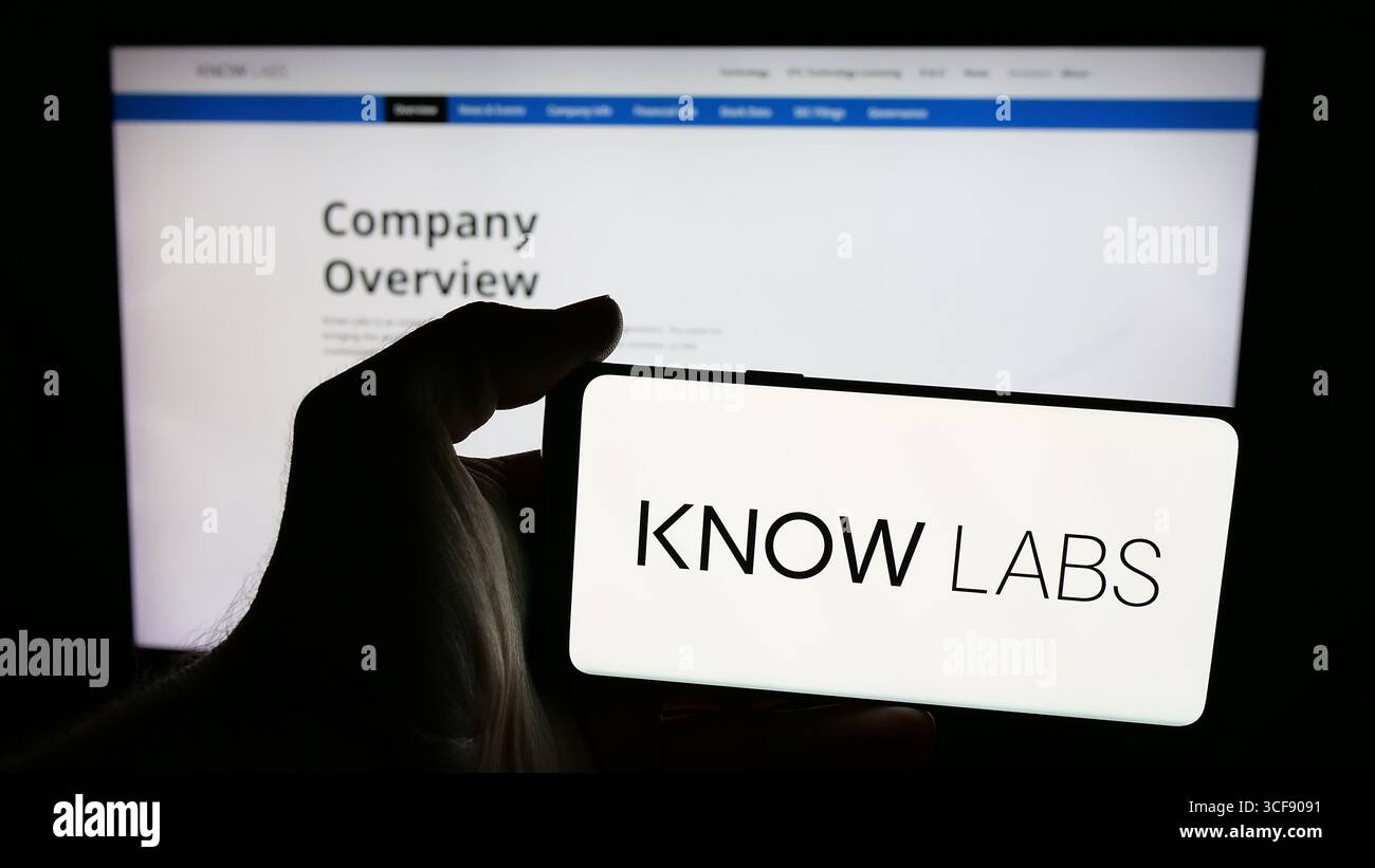 Stoccarda, Germania - 08-18-2025: Persona che possiede un telefono cellulare con il logo della società statunitense di dispositivi medici Know Labs Inc. Sullo schermo davanti alla pagina Web. Foto Stock