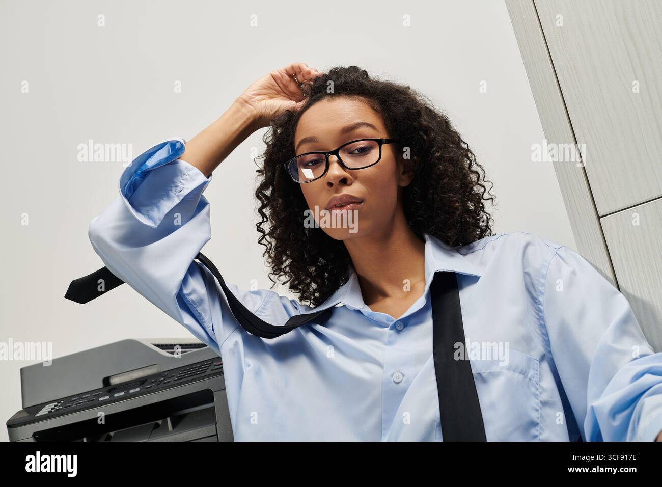 Giovane e bella donna con un abbigliamento casual per affari trasmette equilibrio ed eleganza in un ufficio contemporaneo. Foto Stock