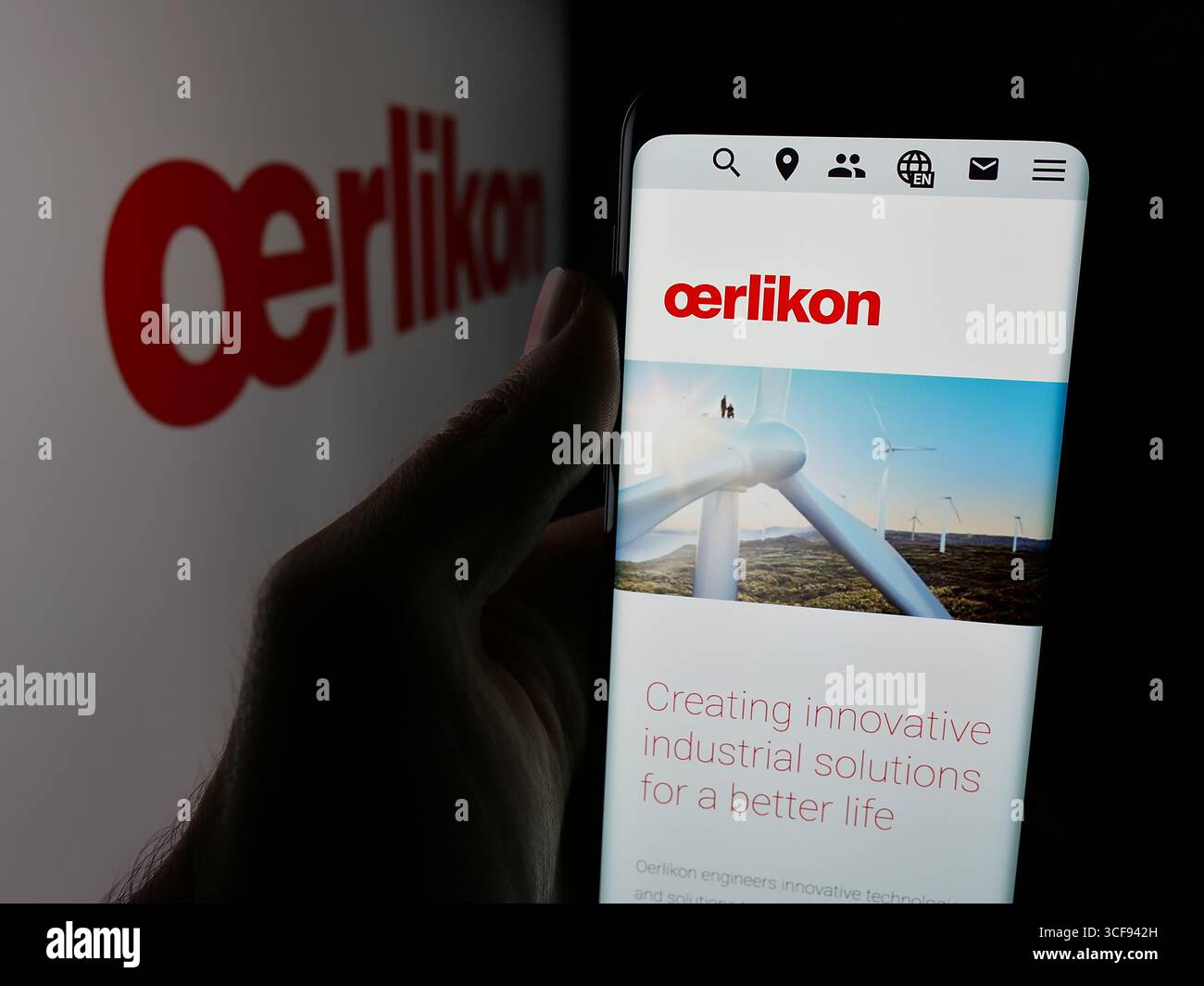 Stoccarda, Germania - 20-08-2025: Persona che detiene il cellulare con pagina web della società svizzera OC Oerlikon Corporation AG sullo schermo davanti al logo. Foto Stock