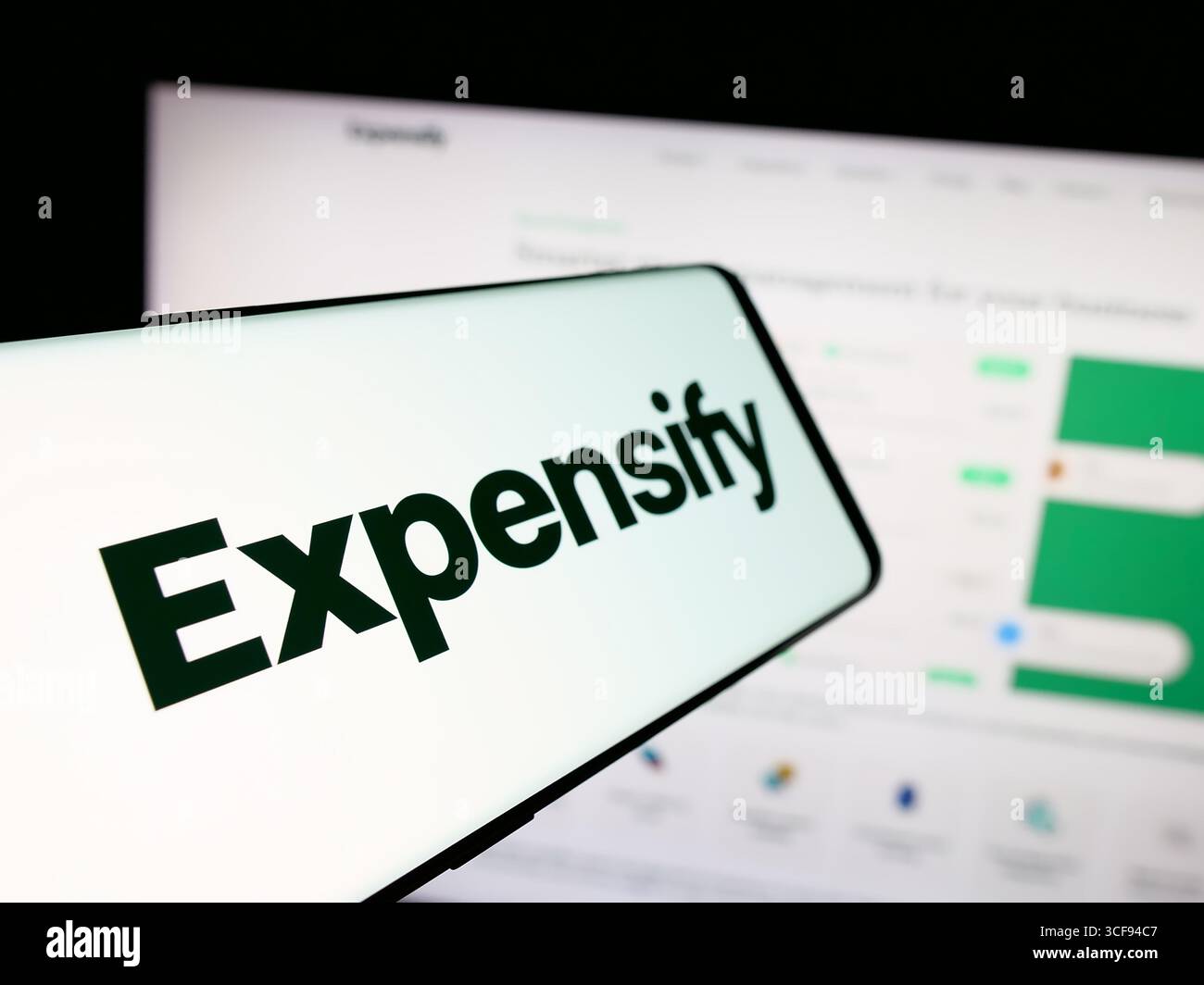 Stoccarda, Germania - 20-08-2025: Smartphone con logo della società di gestione spese Expensify Inc. Sullo schermo davanti al sito Web Foto Stock