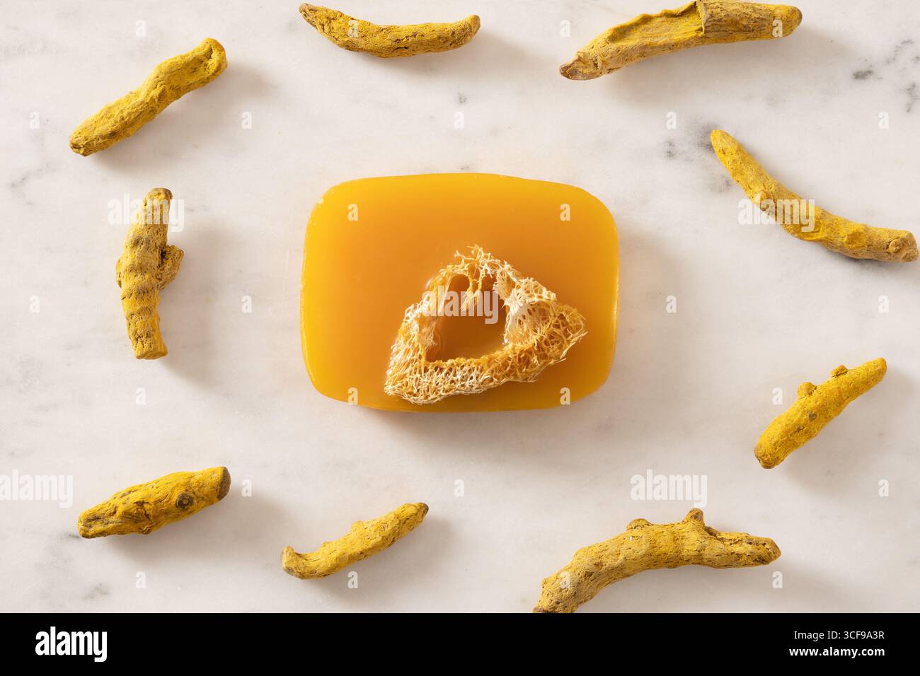 Sapone curcuma e radice di curcuma in polvere su sfondo bianco marmo. Prodotto per la cura della pelle biologico perfetto per il benessere, la bellezza e la cura organica del corpo Foto Stock