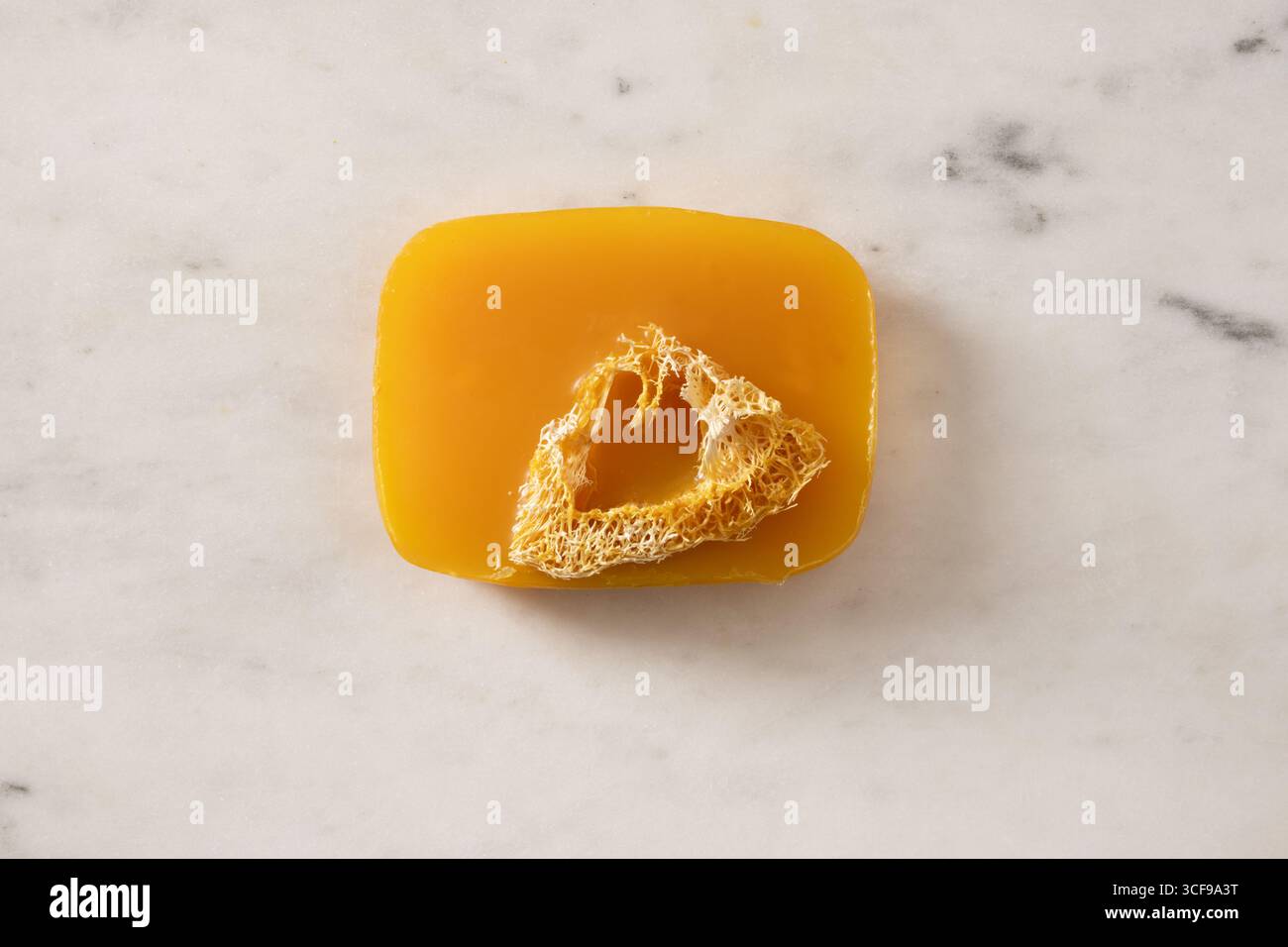 Sapone curcuma su sfondo bianco marmo. Prodotti per la cura della pelle biologici e accessori per il bagno. Vista dall'alto. Verticale. Foto Stock