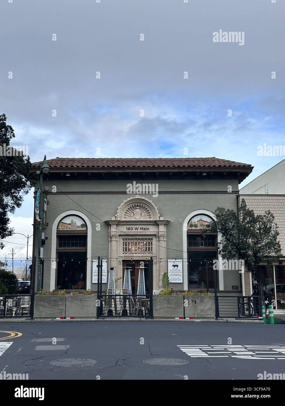 Un edificio storico situato al 160 di W Main Street con una facciata decorativa ornata, finestre ad arco e tetto piastrellato in stile spagnolo - Immagine stock catturata con smartphone