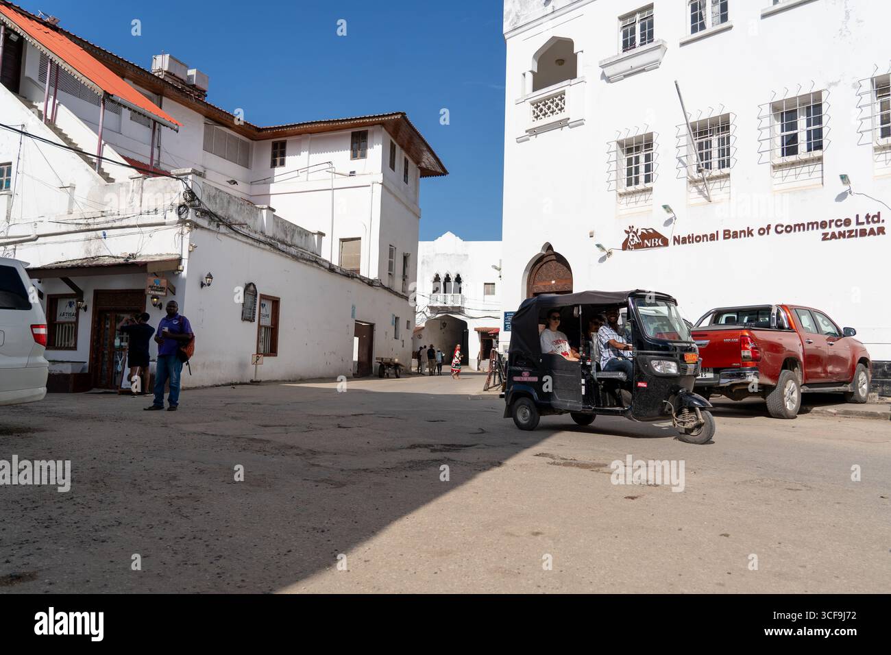 Strada con tuk-tuk ed edifici storici a Stone Town, Zanzibar Foto Stock