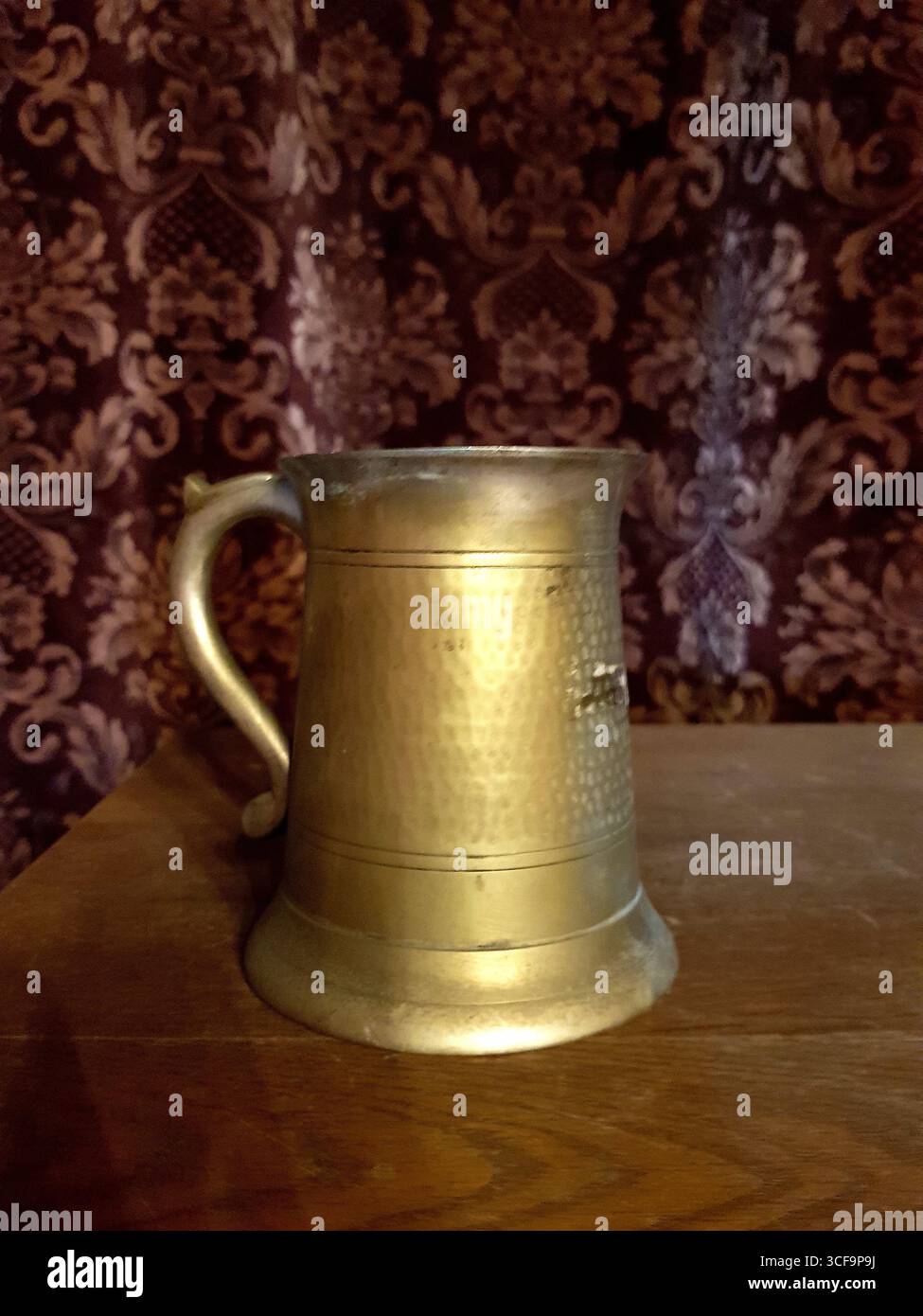 Un tankard medievale con un arazzo alle spalle. Foto Stock