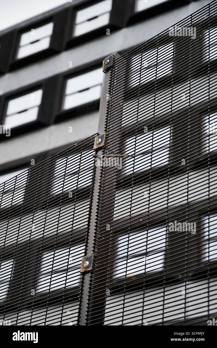 Recinzione di sicurezza grigia di fronte a un edificio di uffici grigi, Regno Unito Foto Stock
