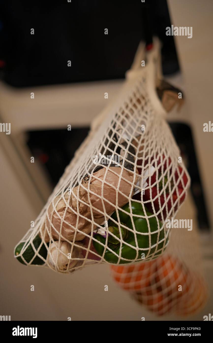 Primo piano di verdure in una borsa riutilizzabile in rete appesa alla galera degli yacht, stile di vita eco-sostenibile e concetto di zero rifiuti Foto Stock