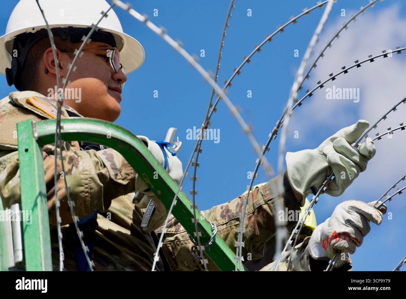 Brownsville, Stati Uniti. 12 agosto 2025. Le guardie nazionali del Texas, sotto la Joint Task Force-Southern Border, installano filo a fisarmonica lungo il muro di confine meridionale con il Messico, 12 agosto 2025 vicino a Brownsville, Texas. I soldati sono stati inviati al confine dal presidente Trump a sostegno dell'operazione Lone Star. Credito: SSgt. Derek Gutierrez/US Air Force Photo/Alamy Live News Foto Stock