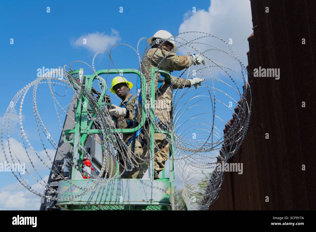 Brownsville, Stati Uniti. 12 agosto 2025. Le guardie nazionali del Texas, sotto la Joint Task Force-Southern Border, installano filo a fisarmonica lungo il muro di confine meridionale con il Messico, 12 agosto 2025 vicino a Brownsville, Texas. I soldati sono stati inviati al confine dal presidente Trump a sostegno dell'operazione Lone Star. Credito: SSgt. Derek Gutierrez/US Air Force Photo/Alamy Live News Foto Stock