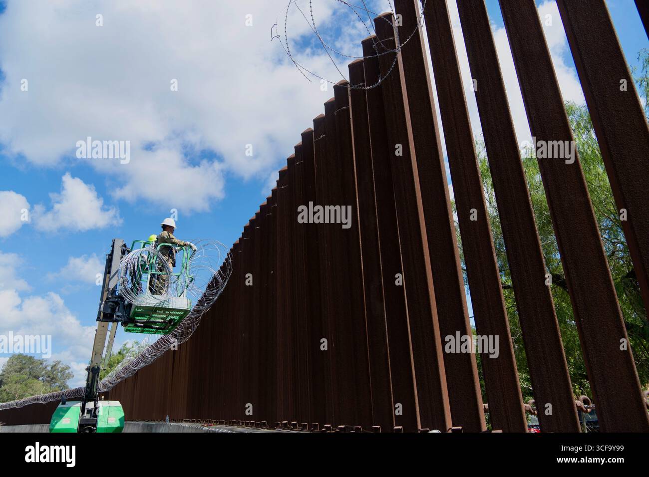 Brownsville, Stati Uniti. 12 agosto 2025. Le guardie nazionali del Texas, sotto la Joint Task Force-Southern Border, installano filo a fisarmonica lungo il muro di confine meridionale con il Messico, 12 agosto 2025 vicino a Brownsville, Texas. I soldati sono stati inviati al confine dal presidente Trump a sostegno dell'operazione Lone Star. Credito: SSgt. Derek Gutierrez/US Air Force Photo/Alamy Live News Foto Stock