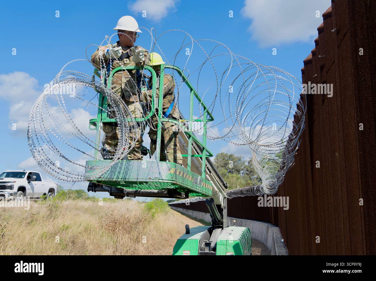Brownsville, Stati Uniti. 12 agosto 2025. Le guardie nazionali del Texas, sotto la Joint Task Force-Southern Border, installano filo a fisarmonica lungo il muro di confine meridionale con il Messico, 12 agosto 2025 vicino a Brownsville, Texas. I soldati sono stati inviati al confine dal presidente Trump a sostegno dell'operazione Lone Star. Credito: SSgt. Derek Gutierrez/US Air Force Photo/Alamy Live News Foto Stock