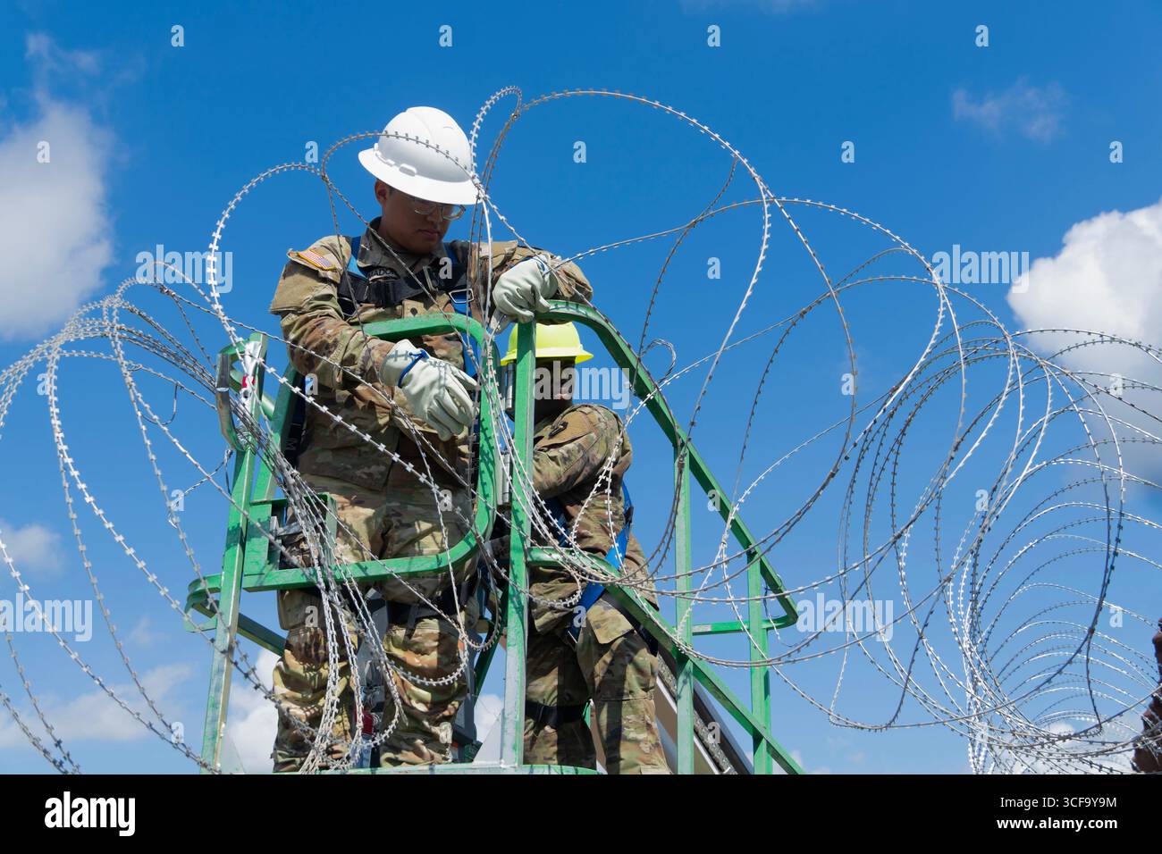 Brownsville, Stati Uniti. 12 agosto 2025. Le guardie nazionali del Texas, sotto la Joint Task Force-Southern Border, installano filo a fisarmonica lungo il muro di confine meridionale con il Messico, 12 agosto 2025 vicino a Brownsville, Texas. I soldati sono stati inviati al confine dal presidente Trump a sostegno dell'operazione Lone Star. Credito: SSgt. Derek Gutierrez/US Air Force Photo/Alamy Live News Foto Stock