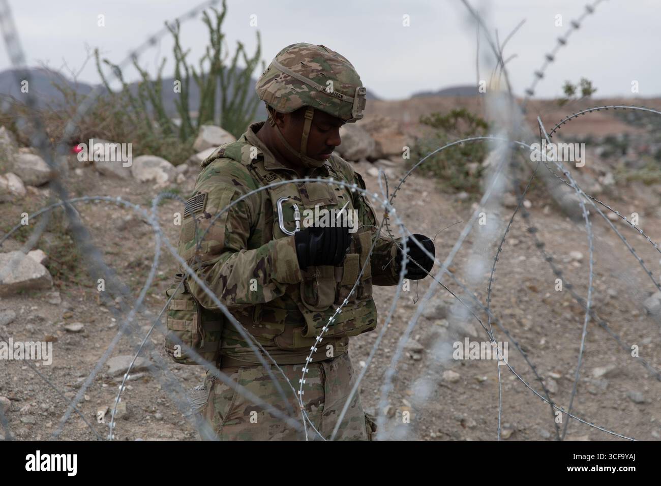 Sunland Park, Stati Uniti. 16 agosto 2025. United States Army Pvt. 1st Class Dominick Harrison, con la 642nd Engineer Support Company, assegnata alla Joint Task Force-Southern Border, installa filo a fisarmonica lungo il muro di confine meridionale con il Messico, 16 agosto 2025 vicino a Sunland Park, nuovo Messico. Credito: SPC. Michael Graf/US Army Photo/Alamy Live News Foto Stock