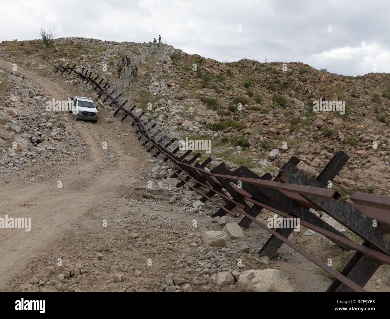 Sunland Park, Stati Uniti. 16 agosto 2025. Un veicolo di pattuglia di frontiera degli Stati Uniti pattuglia una strada di servizio sterrata lungo la nuova barriera del dissuasore che attraversa un arroyo lungo il muro di confine meridionale con il Messico, 16 agosto 2025 vicino a Sunland Park, New Mexico. Credito: SPC. Michael Graf/US Army Photo/Alamy Live News Foto Stock