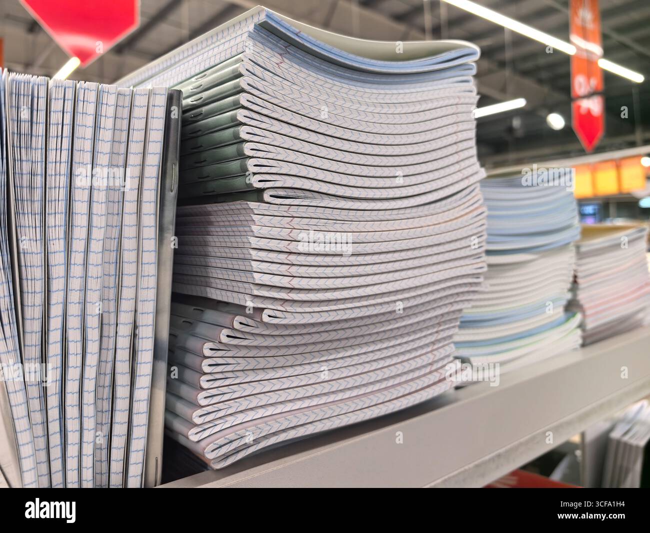 In un corridoio del negozio sono organizzati diversi quaderni e articoli di cancelleria, che presentano una selezione vivace perfetta per gli studenti che si preparano per la scuola Foto Stock