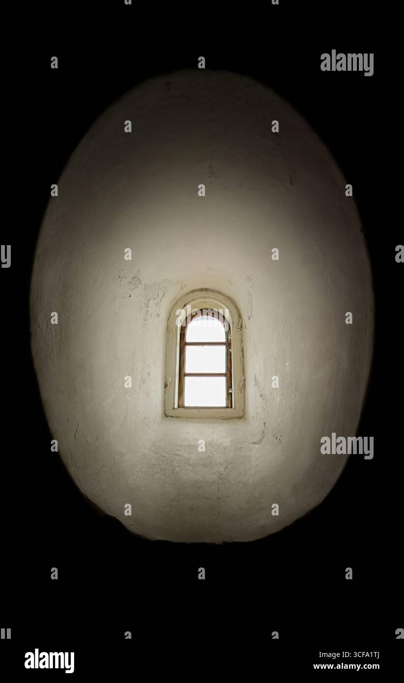 Una piccola finestra arrotondata profonda nelle pareti bianche del faro di Hammeren diventa un portale per la quiete, la contemplazione, le storie per metà dimenticate. Foto Stock