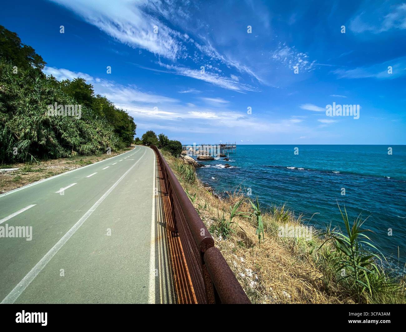 Pista ciclabile panoramica che si snoda lungo la pittoresca costa dei Trabocchi a Rocca San Giovanni, in Abruzzo, Italia, con tradizionali piattaforme di pesca e stordimento Foto Stock