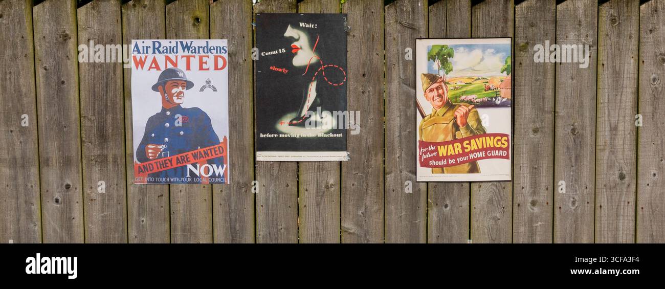 Poster vintage della Propaganda della Guerra Mondiale esposti contro la recinzione di legno Foto Stock