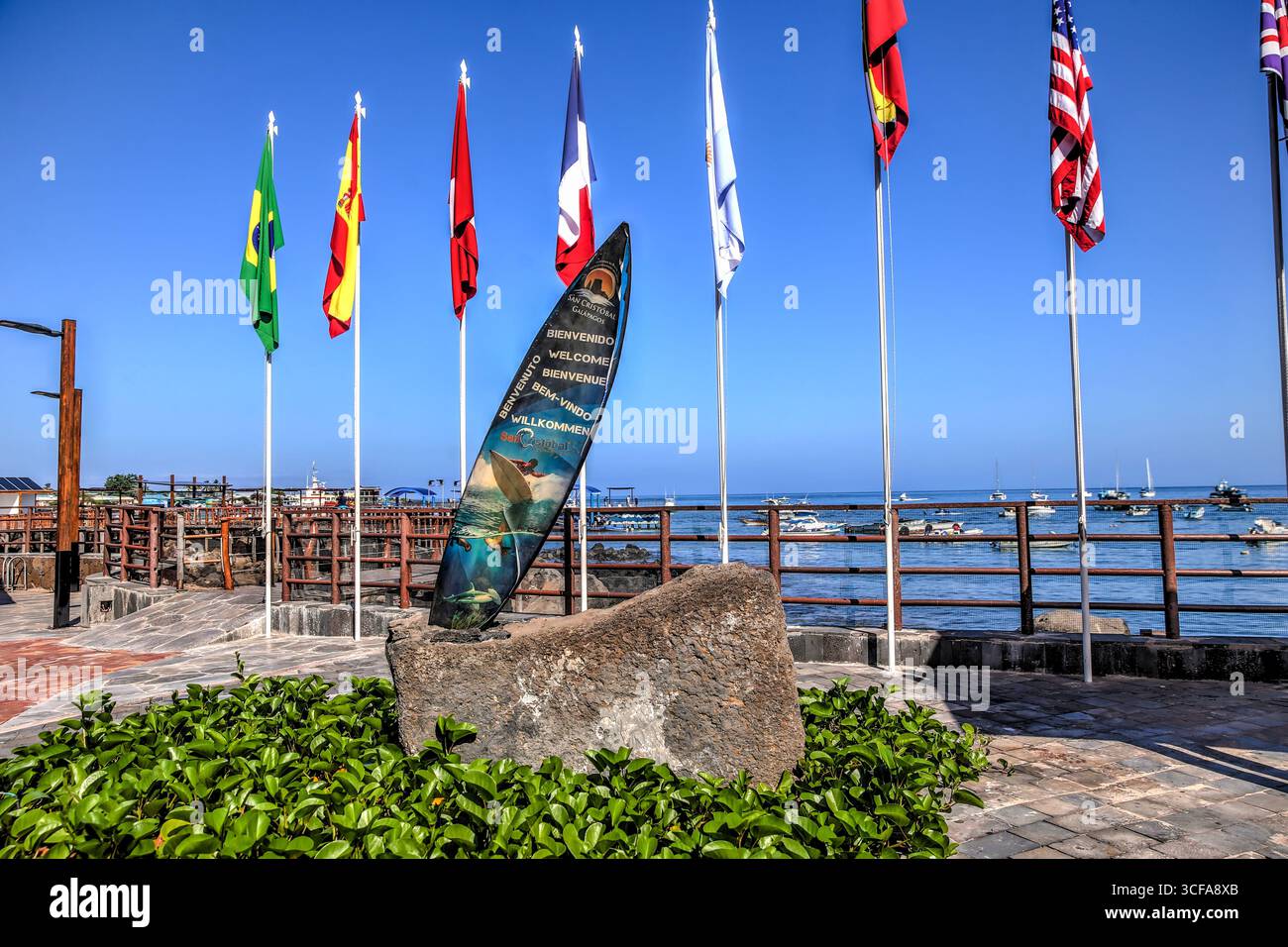Isola di San Cristóbal, Isole Galápagos, Ecuador: 29 marzo 2018: Monumento di benvenuto e bandiere internazionali lungo il lungomare di San Cristobal Foto Stock